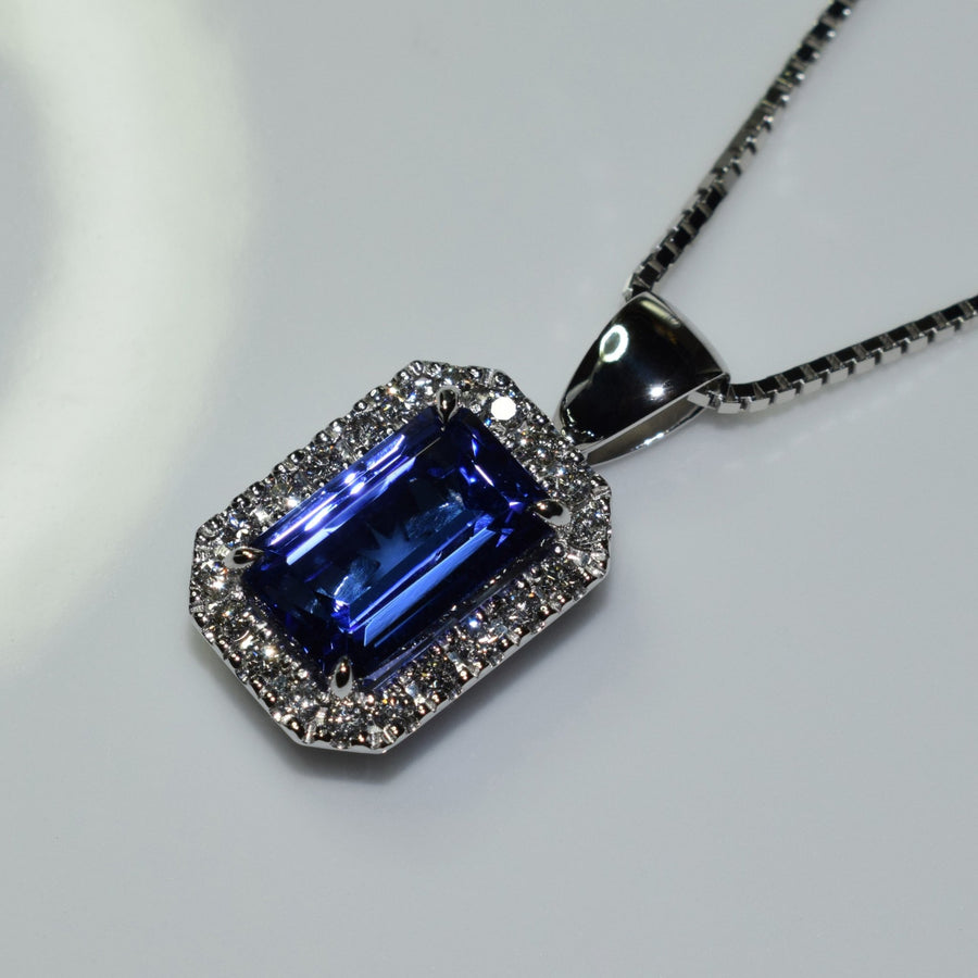Emerald cut tanzanite and diamond halo set in 18ct white gold