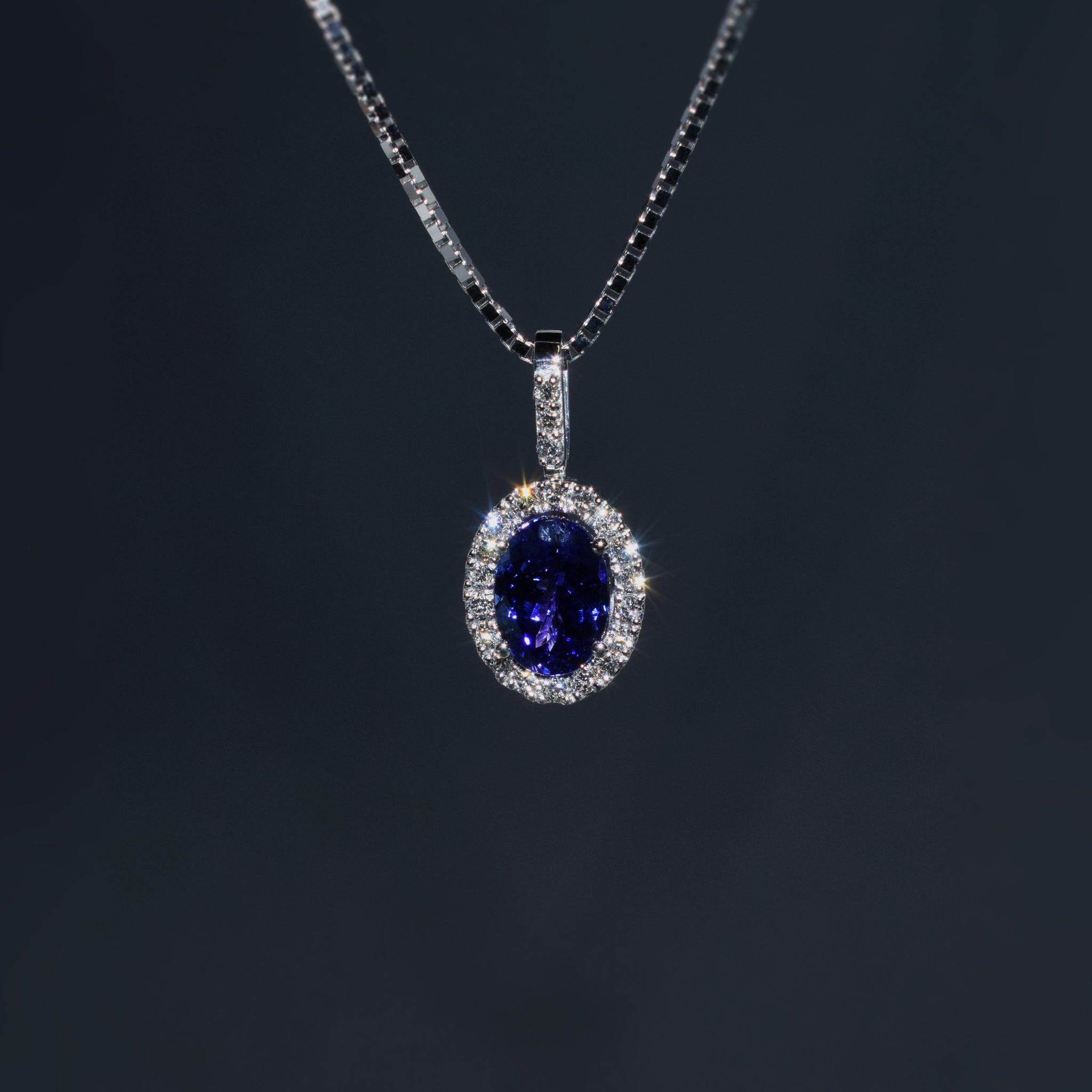 Oval tanzanite and diamond halo pendant in platinum