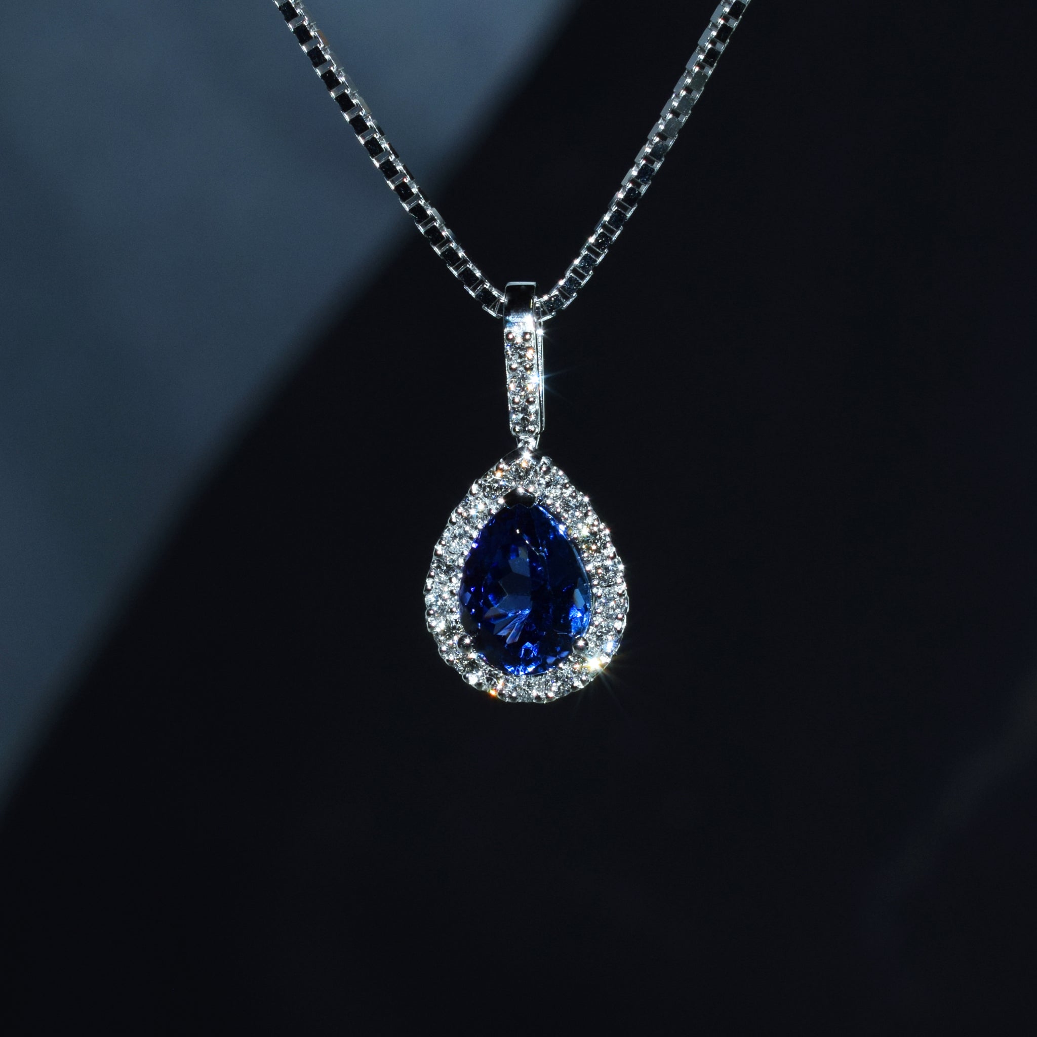 Pear shape tanzanite and diamond halo pendant in platinum