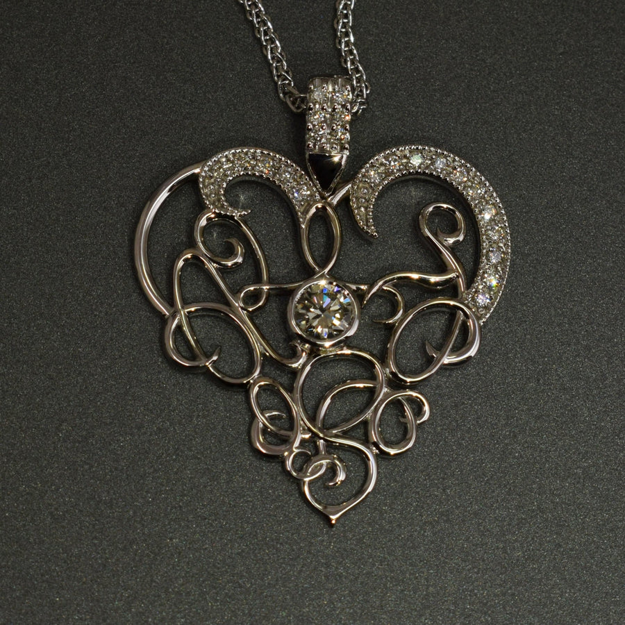 Calligraphy heart shaped pendant with diamonds in 9ct white gold